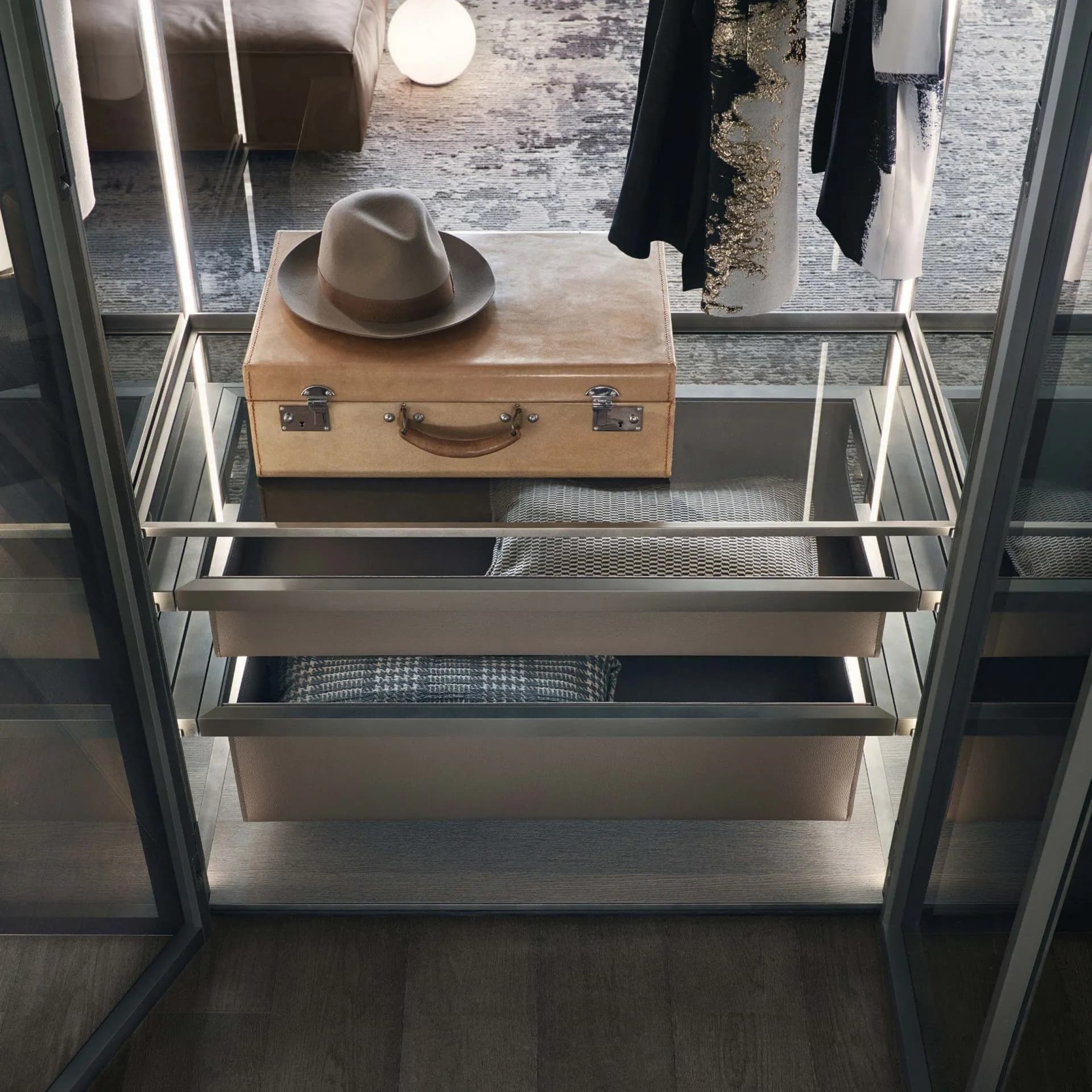 A closet interior seen from above, with leather drawer boxes and a vintage case