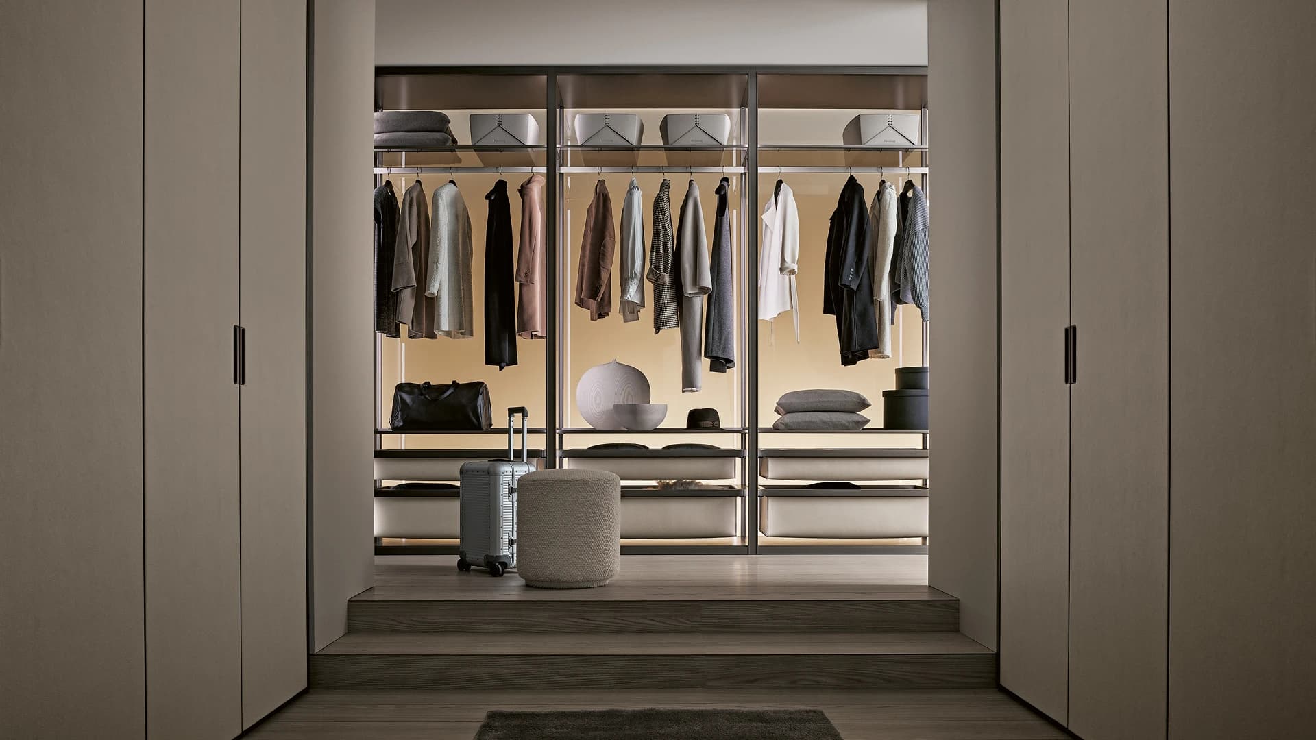 A backlit glazed closet system seen from a bedroom doorway
